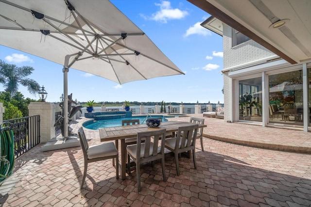 view of patio / terrace featuring fence and a pool with connected hot tub