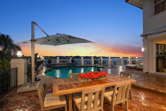 view of swimming pool with outdoor dining space, a pool with connected hot tub, a fenced backyard, and a patio