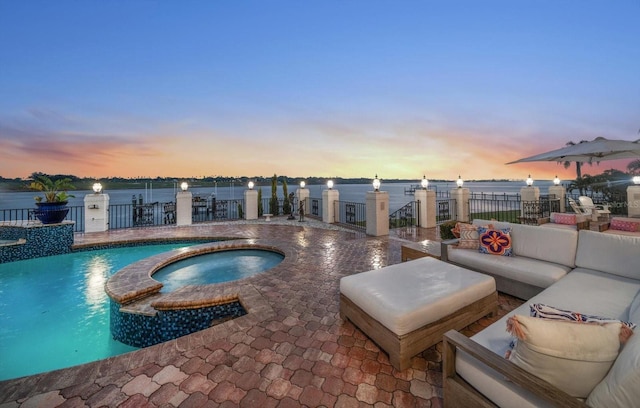 view of swimming pool with a patio, an in ground hot tub, outdoor lounge area, a water view, and a fenced in pool