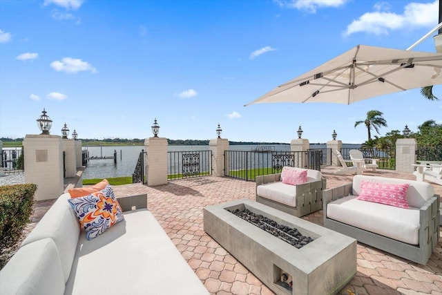 view of patio / terrace featuring a water view and an outdoor living space with a fire pit