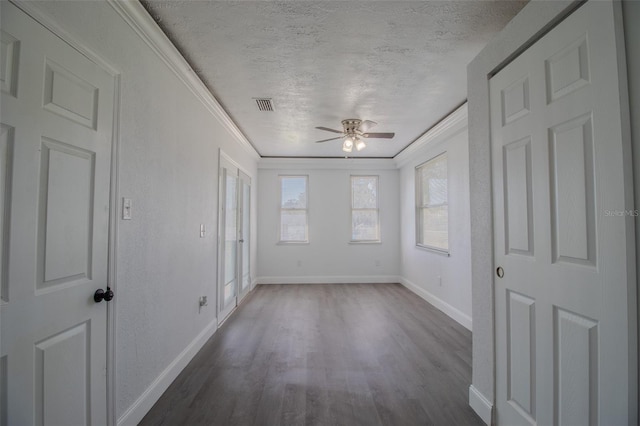 unfurnished room with a textured ceiling, dark hardwood / wood-style floors, ceiling fan, and crown molding