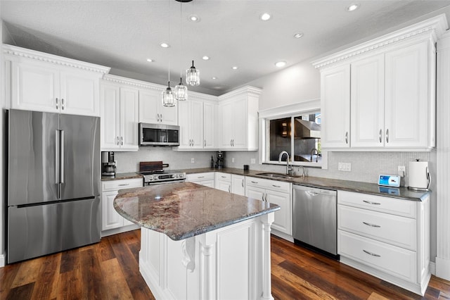 kitchen featuring a kitchen island, appliances with stainless steel finishes, white cabinetry, sink, and dark wood-type flooring