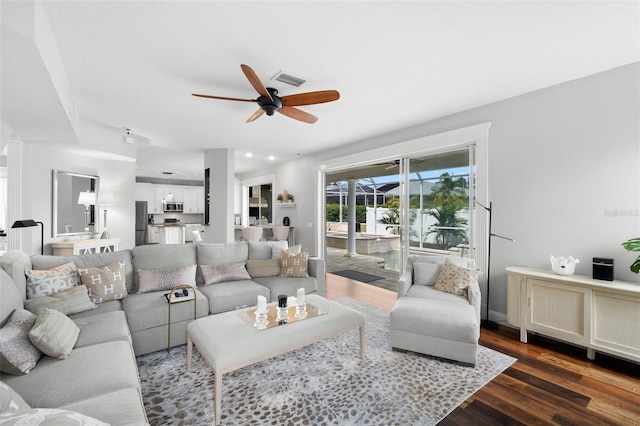 living room featuring dark hardwood / wood-style floors and ceiling fan