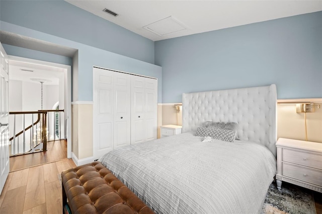 bedroom with light hardwood / wood-style floors and a closet