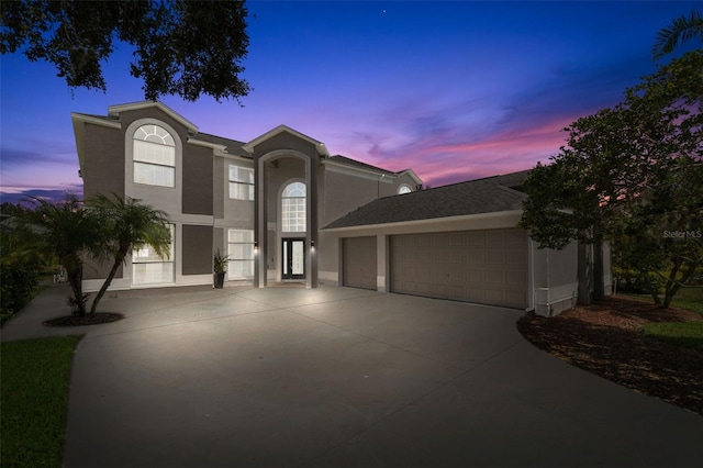 view of front of house featuring stucco siding, concrete driveway, and a garage