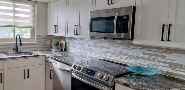 kitchen featuring white cabinetry, sink, appliances with stainless steel finishes, and tasteful backsplash