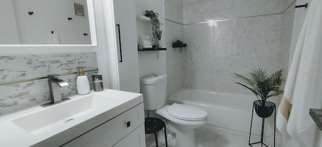 full bathroom featuring tasteful backsplash, tiled shower / bath, vanity, and toilet