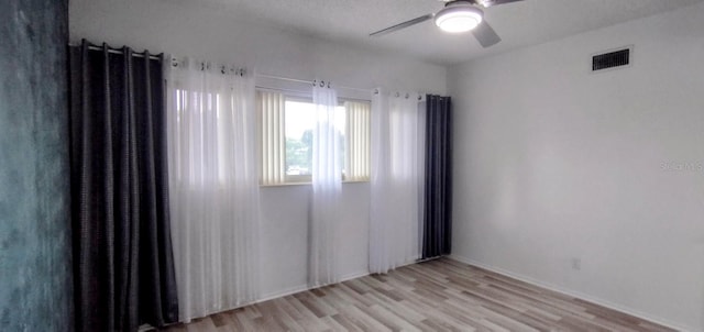 unfurnished room with light wood-type flooring and ceiling fan