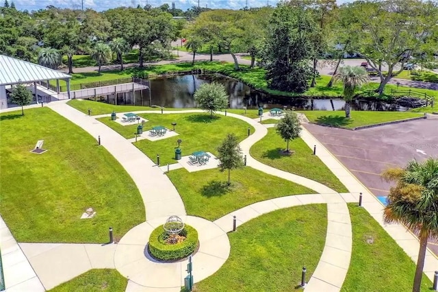 view of property's community with a water view and a lawn