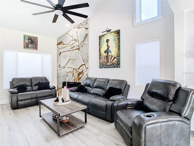 living room with light hardwood / wood-style floors, high vaulted ceiling, a high end fireplace, and ceiling fan