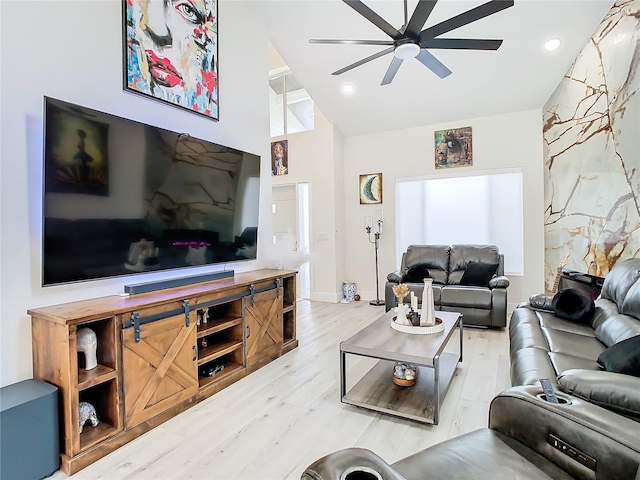 living room featuring ceiling fan, hardwood / wood-style flooring, and vaulted ceiling