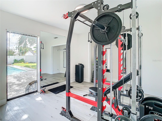 exercise room with light hardwood / wood-style floors