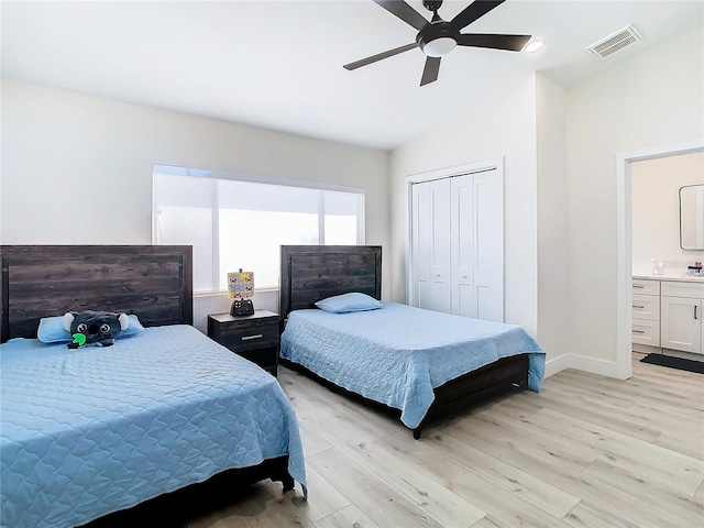 bedroom featuring a closet, connected bathroom, light wood-type flooring, and ceiling fan