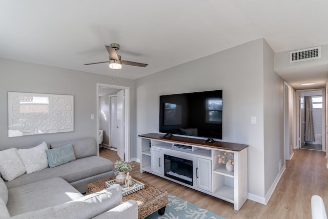 living room with ceiling fan and light hardwood / wood-style flooring