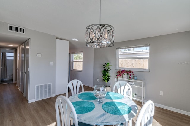 dining room with dark wood-type flooring and a chandelier