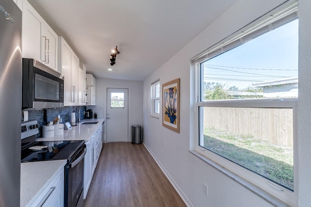 kitchen featuring appliances with stainless steel finishes, decorative backsplash, white cabinets, and sink