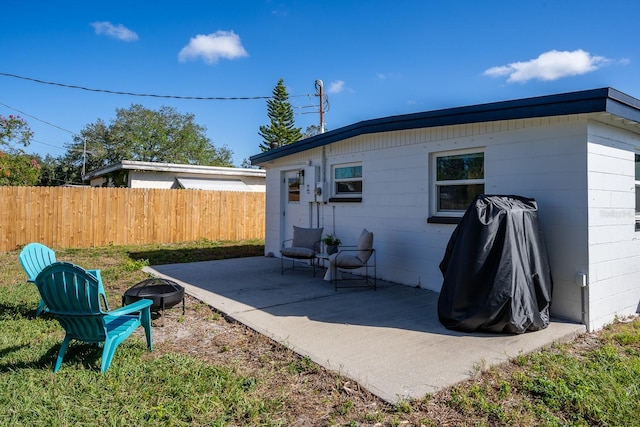 rear view of property featuring a patio area and an outdoor fire pit