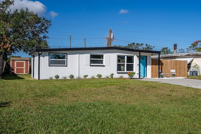 single story home featuring a storage shed and a front yard