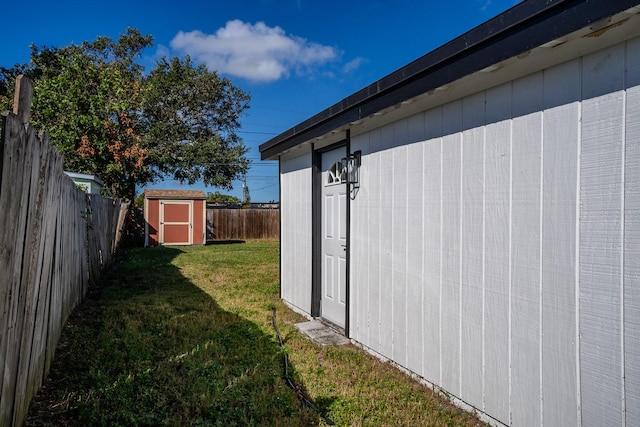 view of side of property with a lawn and a storage unit