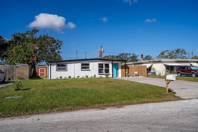 ranch-style house with a front lawn and a storage unit