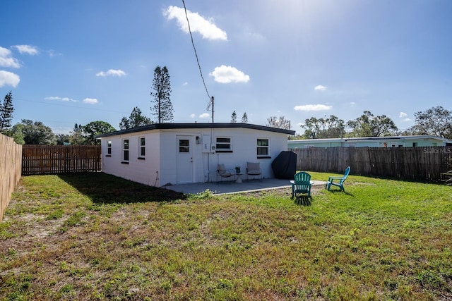 rear view of property with a lawn and a patio