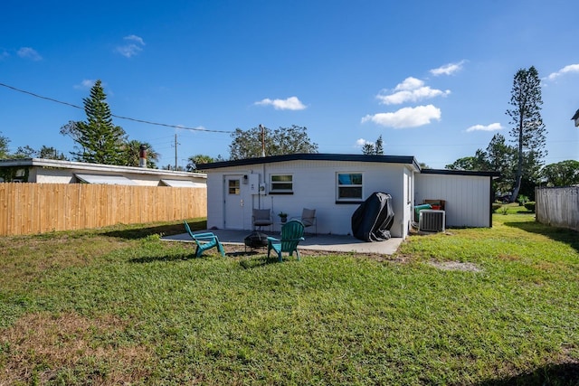 back of property featuring cooling unit, a fire pit, a lawn, and a patio