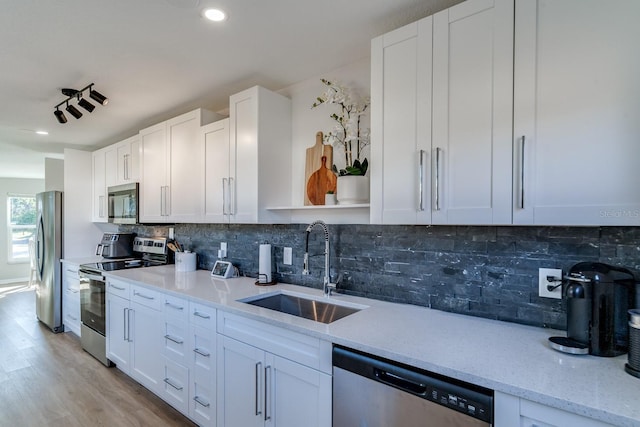 kitchen with stainless steel appliances, white cabinetry, and sink