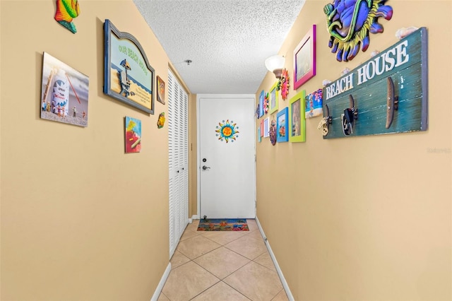 hall with light tile patterned floors and a textured ceiling