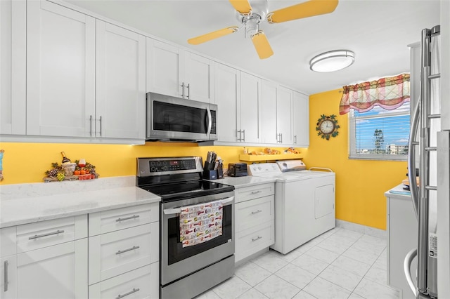 kitchen with ceiling fan, light tile patterned floors, separate washer and dryer, appliances with stainless steel finishes, and white cabinetry