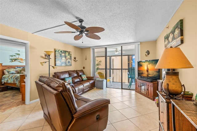 living room featuring floor to ceiling windows, ceiling fan, light tile patterned flooring, and a textured ceiling