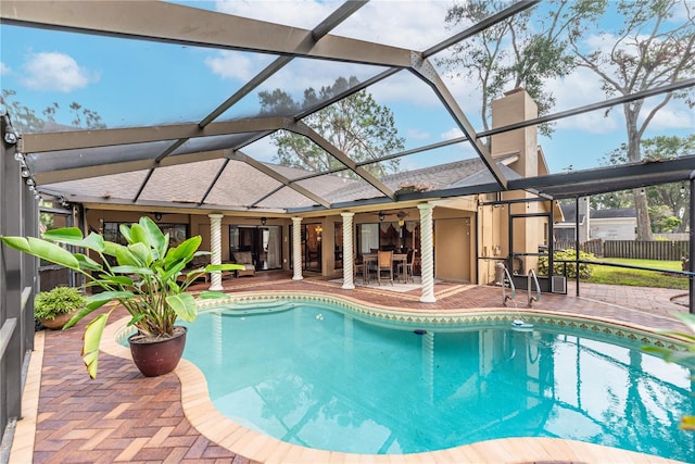 view of pool featuring glass enclosure, ceiling fan, and a patio area