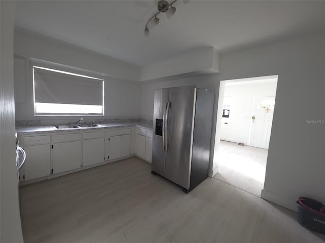 3102 W Leroy St Unit A, Tampa, FL 33607 - kitchen with stainless steel refrigerator with ice dispenser, white cabinets, light countertops, and light wood finished floors