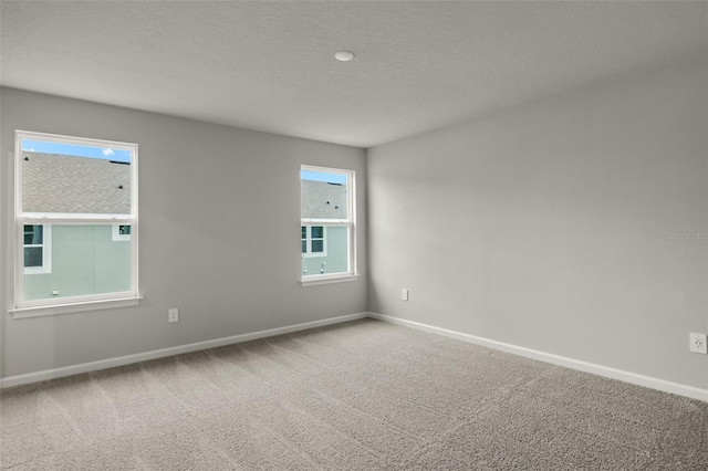 unfurnished room featuring a textured ceiling and carpet floors