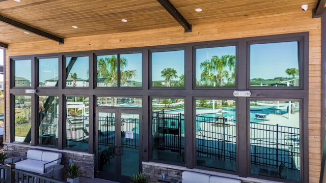 doorway to outside with wood ceiling, a healthy amount of sunlight, and beam ceiling