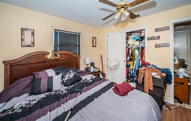 bedroom featuring a closet, a textured ceiling, hardwood / wood-style flooring, and ceiling fan