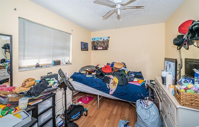 bedroom with ceiling fan, a textured ceiling, and light hardwood / wood-style flooring