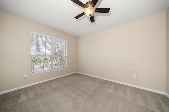 spare room with ceiling fan and light colored carpet