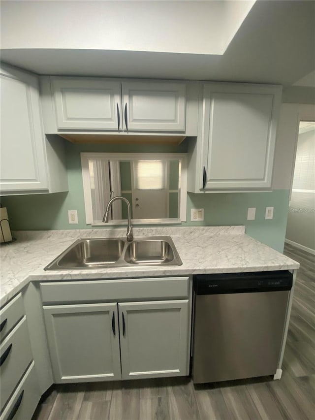 kitchen with sink, white cabinetry, dark hardwood / wood-style flooring, and stainless steel dishwasher