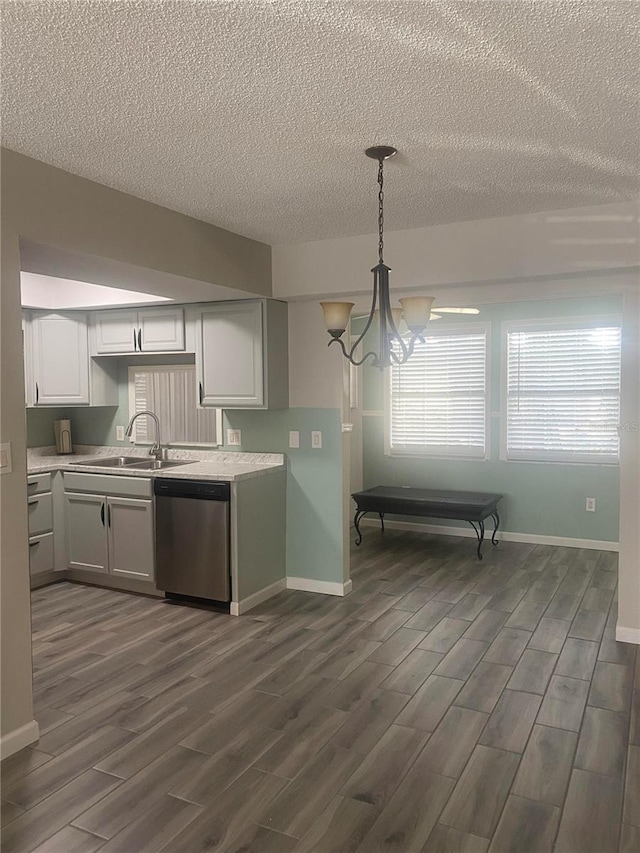 kitchen with dishwasher, dark wood-type flooring, hanging light fixtures, sink, and white cabinetry