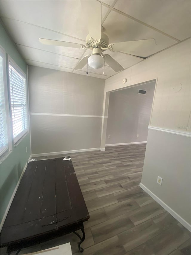 empty room featuring dark wood-type flooring and ceiling fan