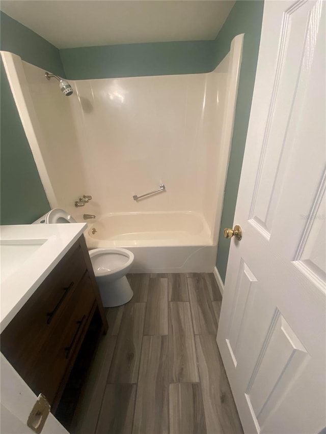 full bathroom with vanity, toilet, bathtub / shower combination, and hardwood / wood-style flooring