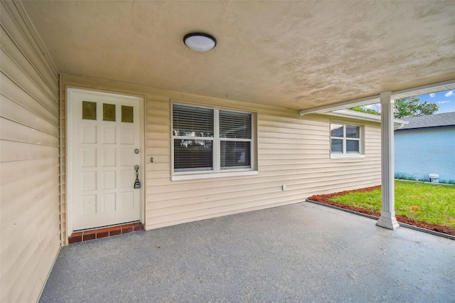 view of exterior entry featuring a patio area