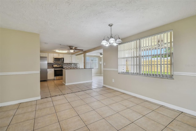 kitchen with pendant lighting, white cabinetry, light tile patterned floors, appliances with stainless steel finishes, and tasteful backsplash