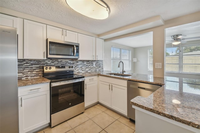 kitchen with white cabinetry, stainless steel appliances, sink, and a textured ceiling