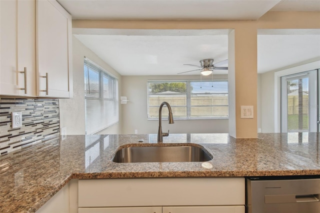 kitchen featuring tasteful backsplash, ceiling fan, white cabinetry, light stone countertops, and sink