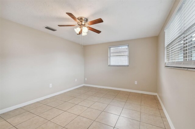 empty room with light tile patterned floors and ceiling fan