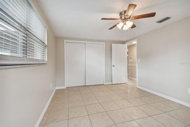 unfurnished bedroom with a closet, ceiling fan, and light tile patterned floors