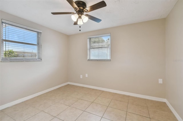 empty room featuring light tile patterned floors and ceiling fan