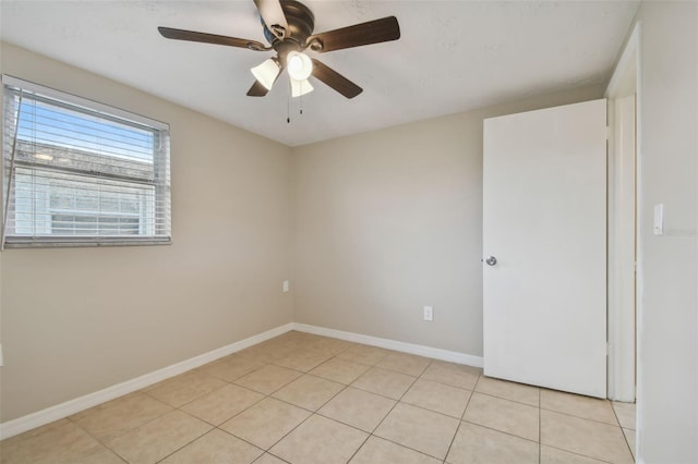 tiled empty room featuring ceiling fan