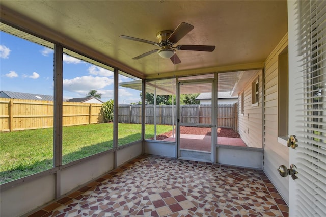 unfurnished sunroom with ceiling fan